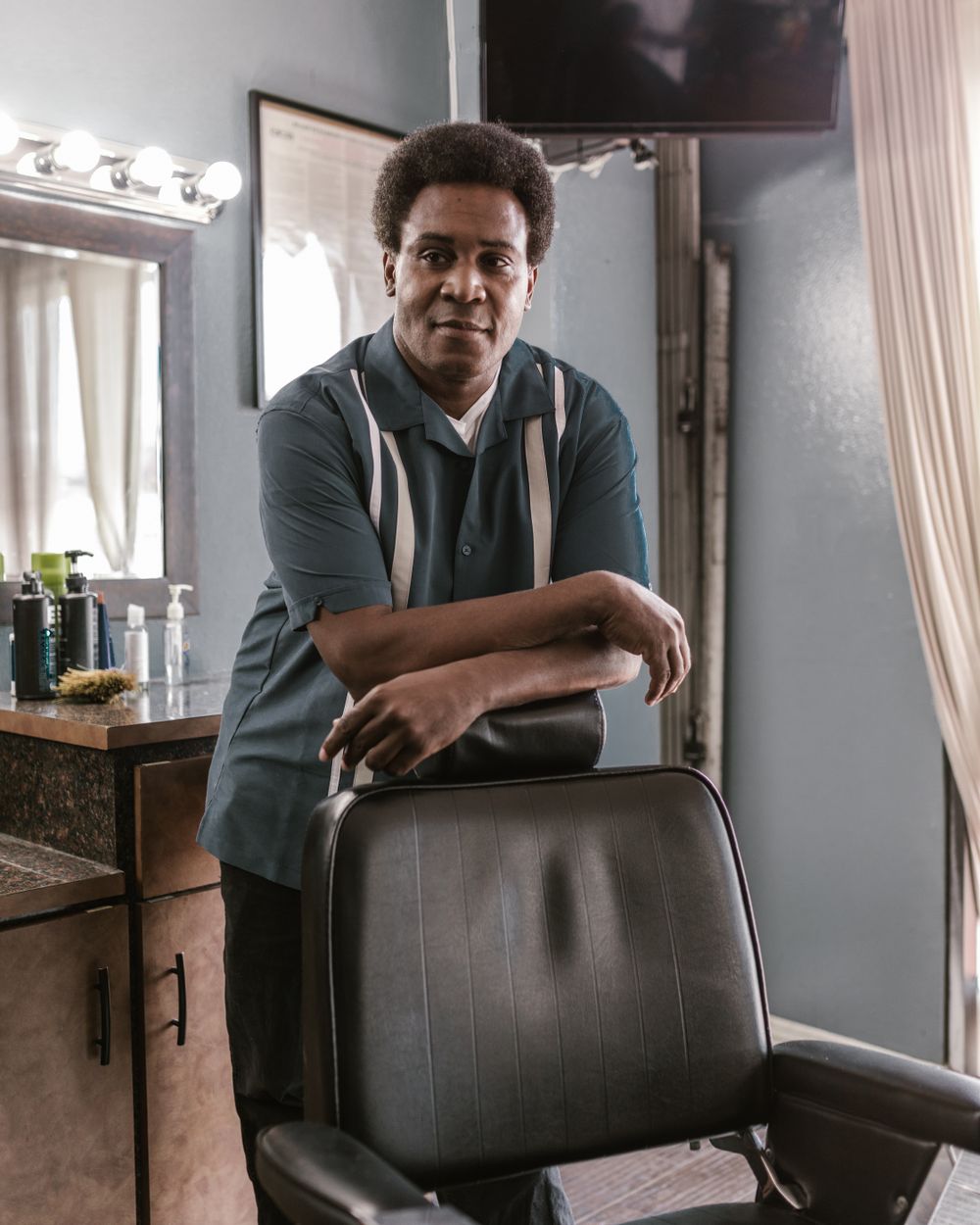 Portrait of Tay, a smiling barber ready at the chair
