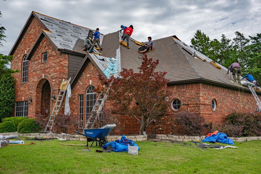 The Red Dirt crew loading shingle bundles onto a roof